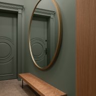 Entryway of BH apartment has a large round mirror
