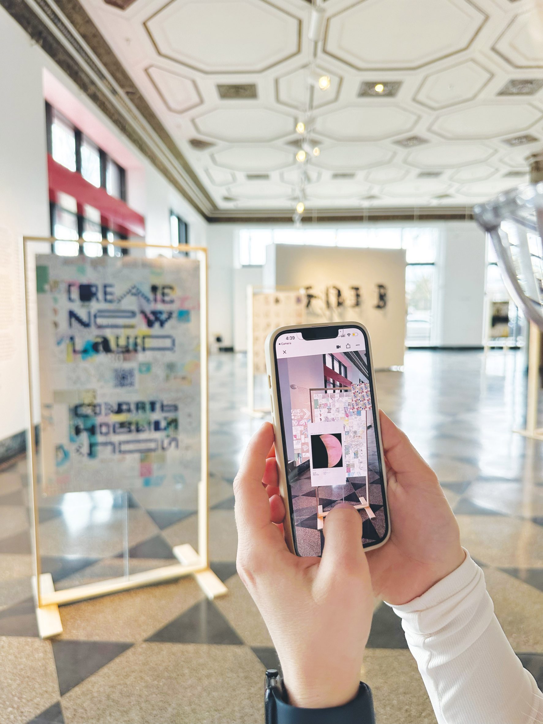 Hands holding phone taking a picture of a presentation board