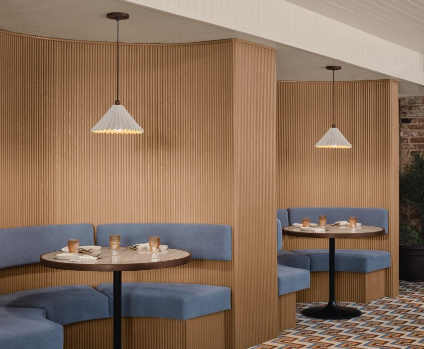 Semi-circular booths with blue velvet seats lined with tambour panelling.