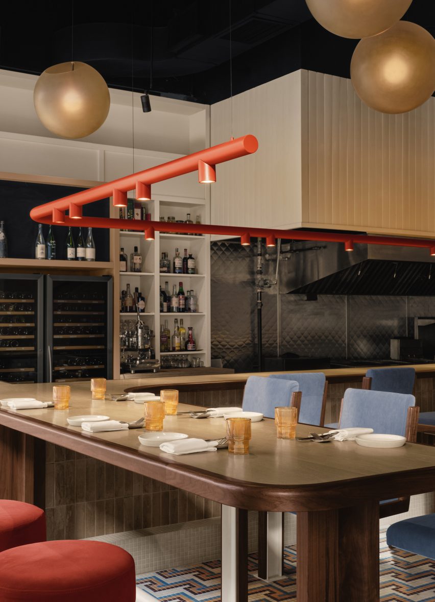 A tubular orange light above the bar counter with blue seating