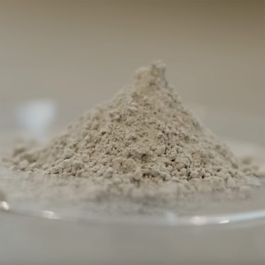 Video still of a pile of grey sand-like matter in a Petri dish