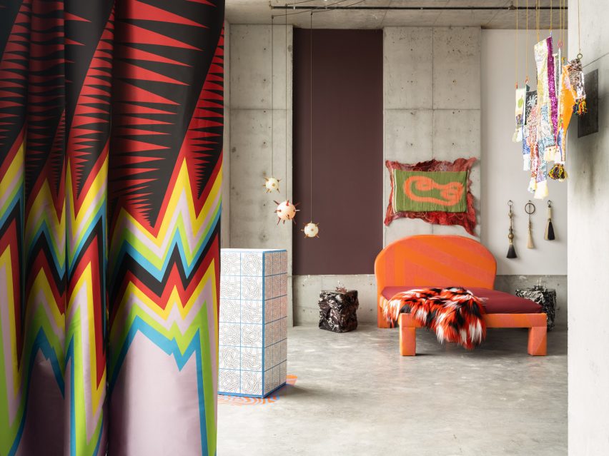 An orange bed with bold curtain