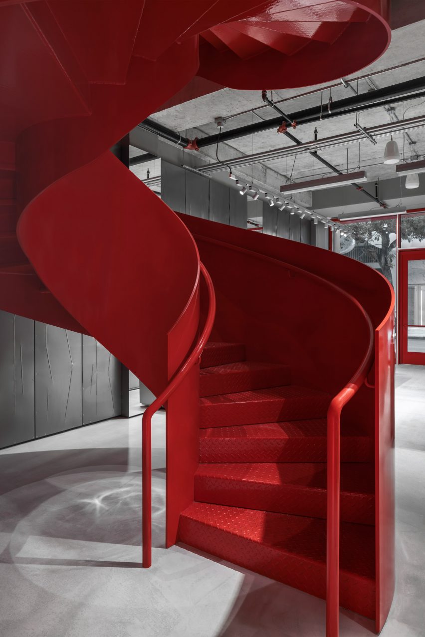 Red spiral staircase with solid balustrades and steps with diamond-plate texture for added grip