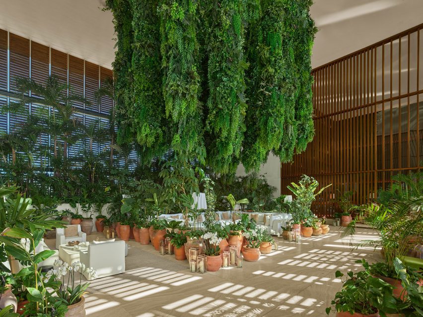 Lobby lounge area positioned beneath an installation of hanging greenery