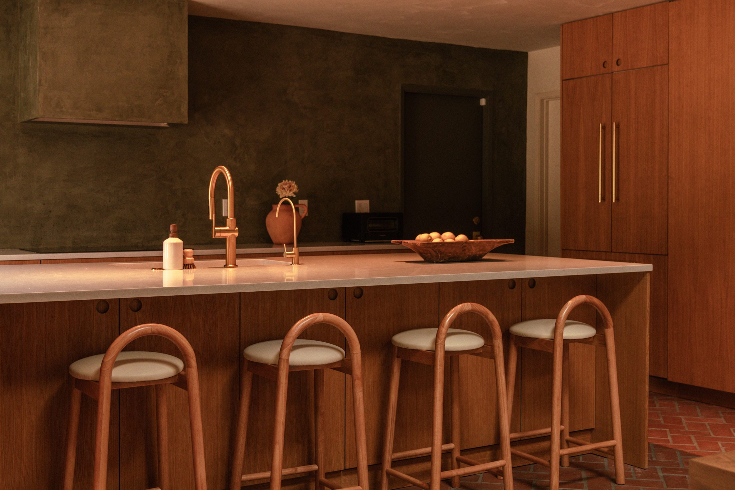 Kitchen with dark green plaster walls and warm millwork