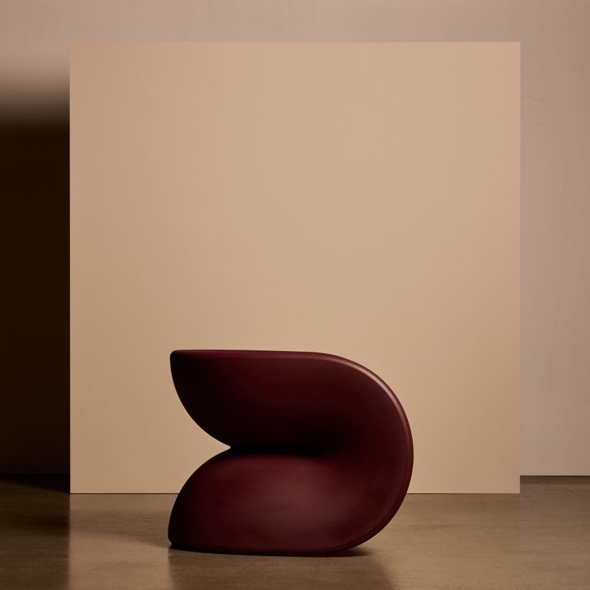Maroon chair against a cream back drop