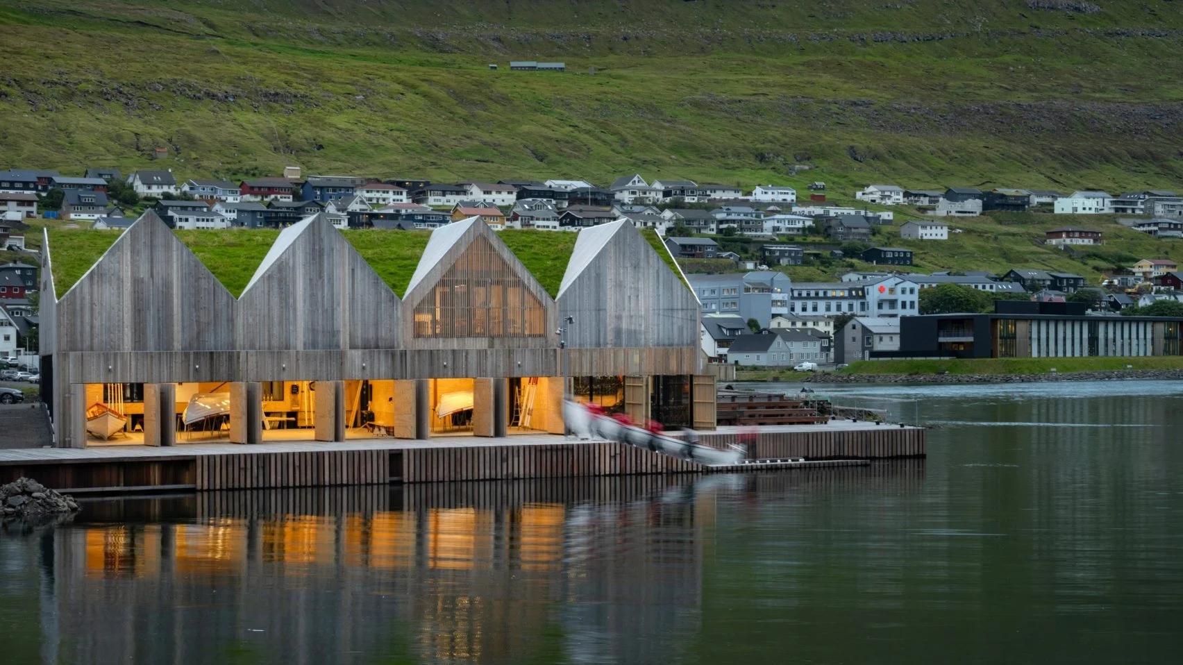 Exterior of rowing club with boat entering water 