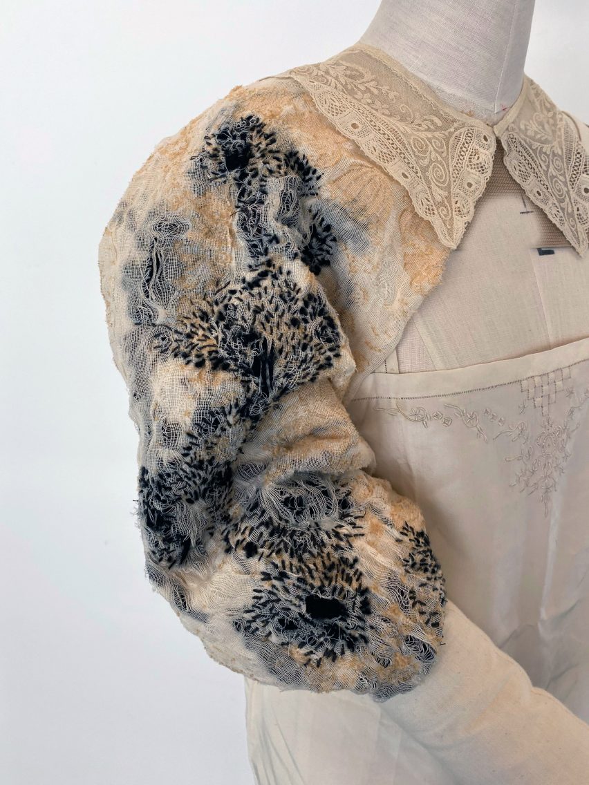 Garment on mannequin with embroidered sleeve and lace collar