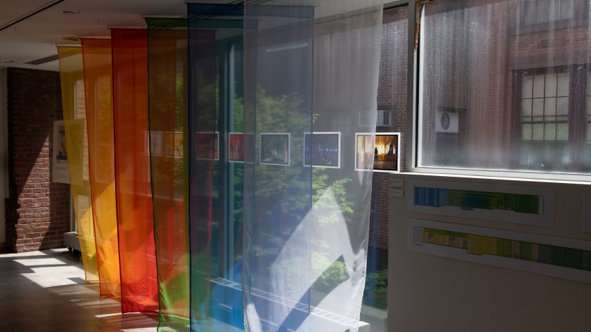 An image of six sheets of translucent fabric hung up next to a window. There is one in each colour of white, blue, green, red, orange and yellow.