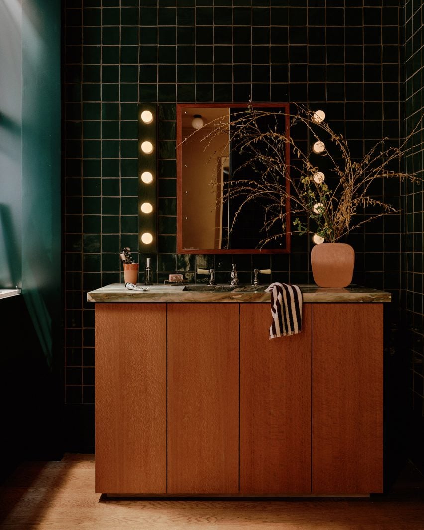 Bathroom vanity in front of green handmade tiles