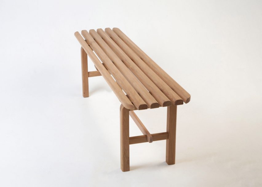 A photograph of a brown wooden bench on a white backdrop.