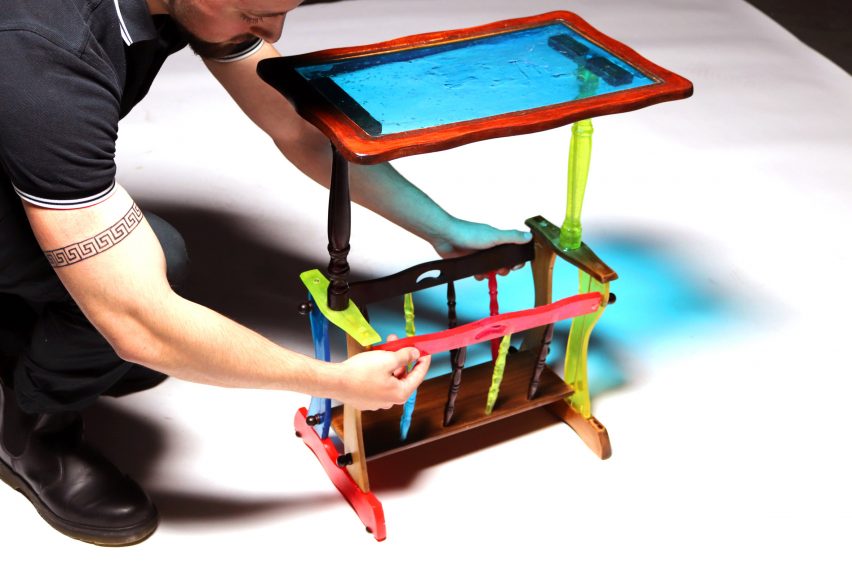 Person handling a multi-coloured side table. 