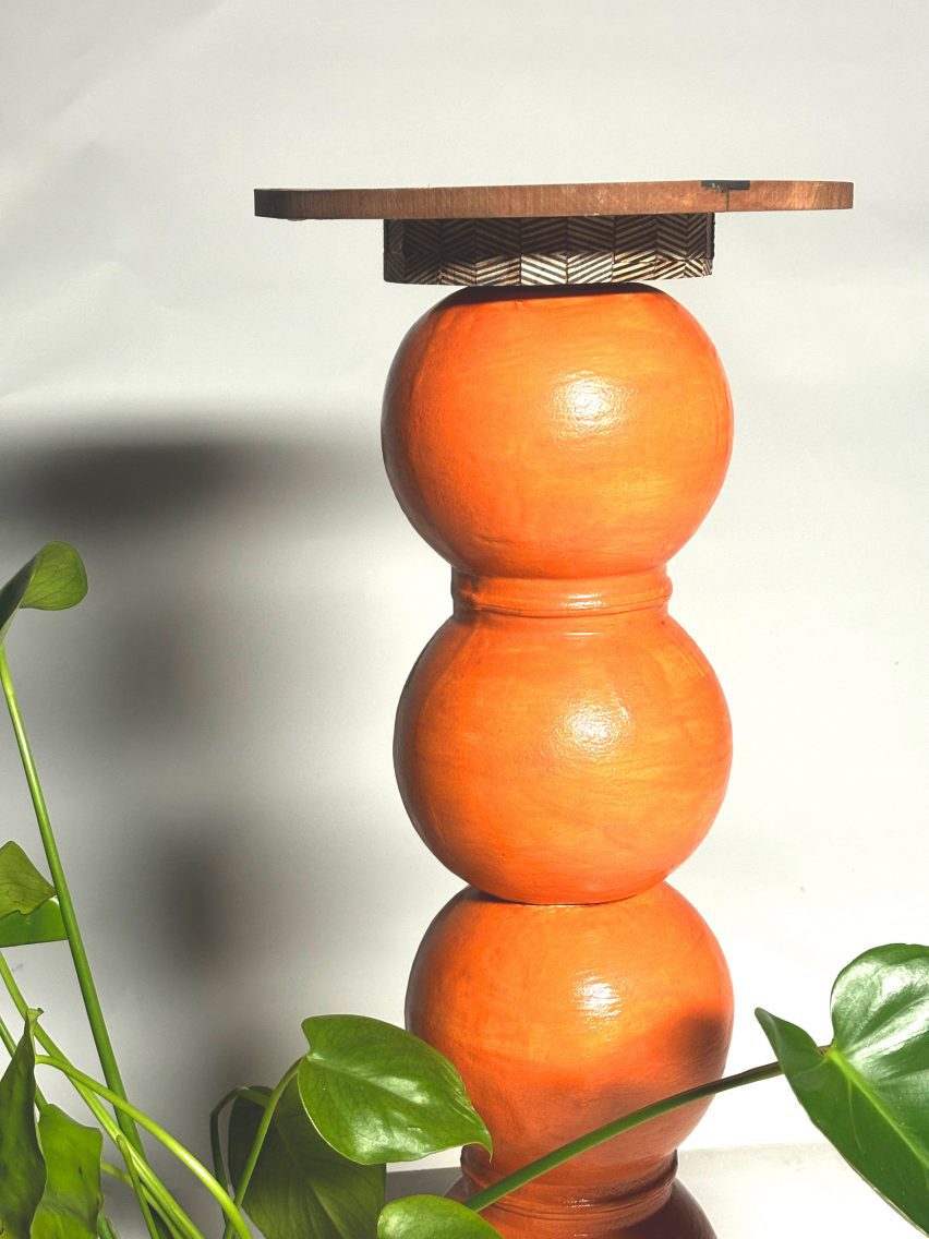 An orange wooden side table with a stacked spherical structure.