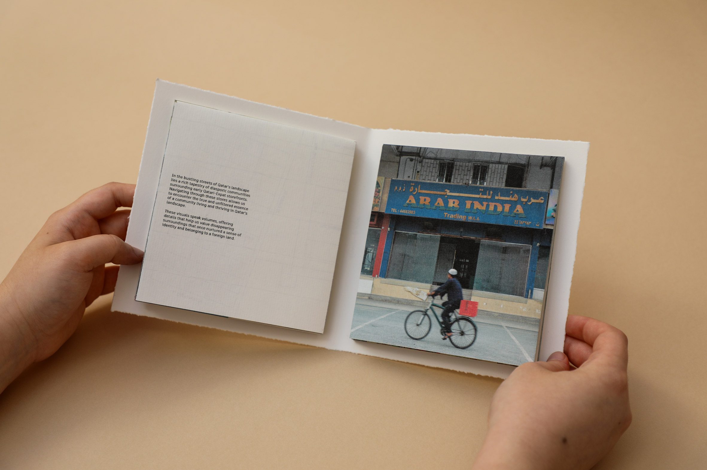 A photograph of a person holding a book against a yellow backdrop.