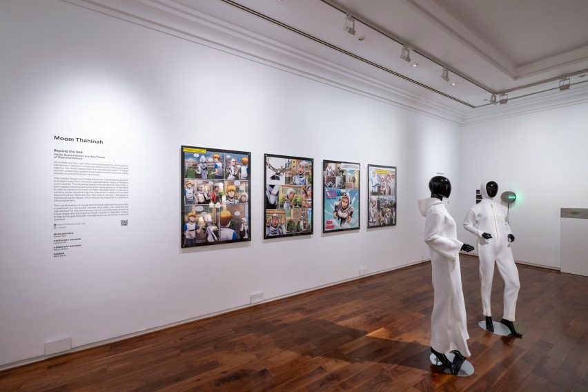 A series of four framed prints on a white wall, with mannequins wearing white outfits in front.