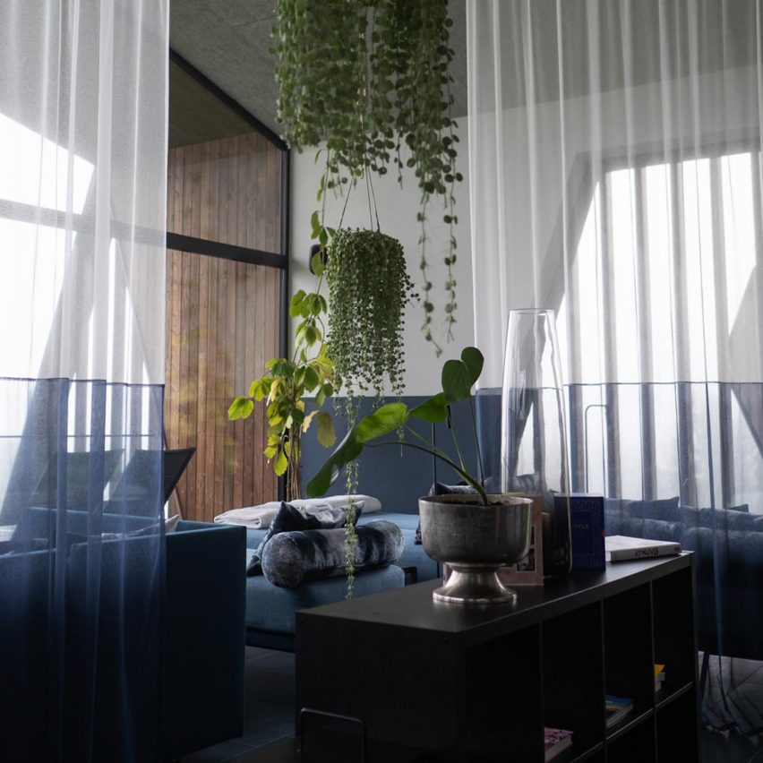 a room with blue furniture and green plants