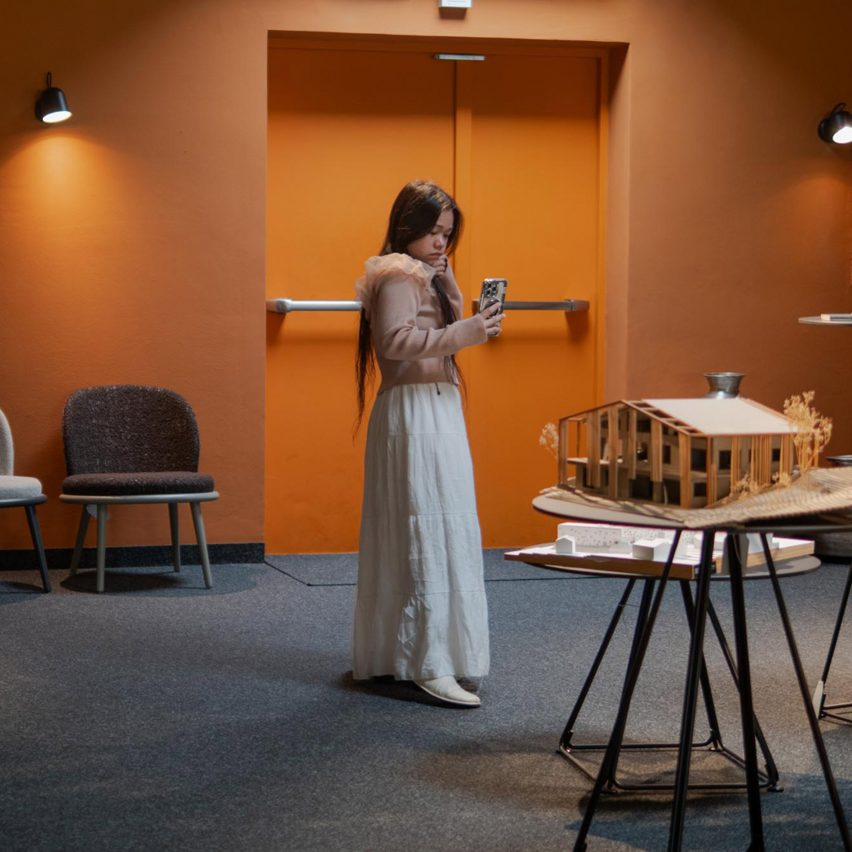 a person taking a photo of an architecture model