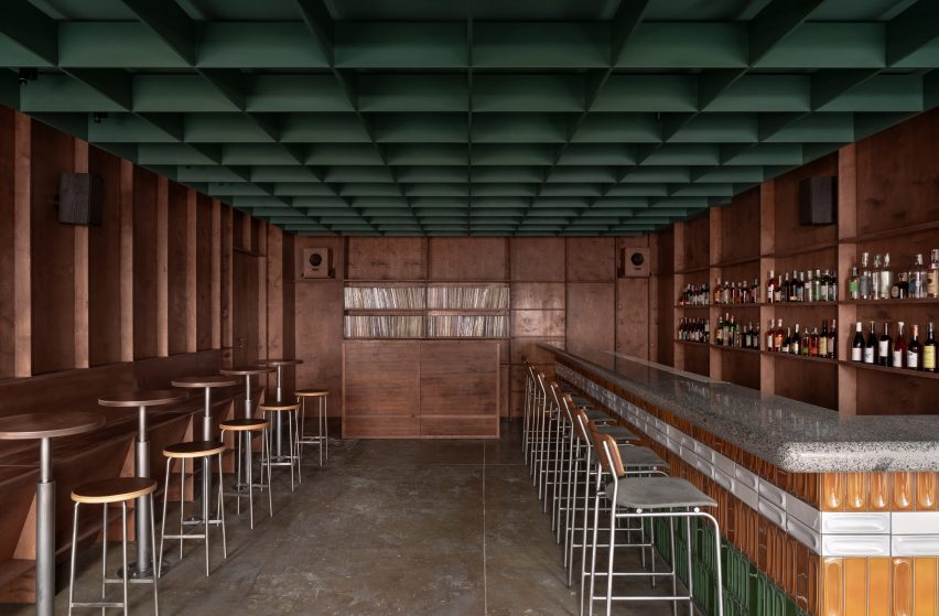 Bar with counter and stools on the right, and additional high-top tables on the left