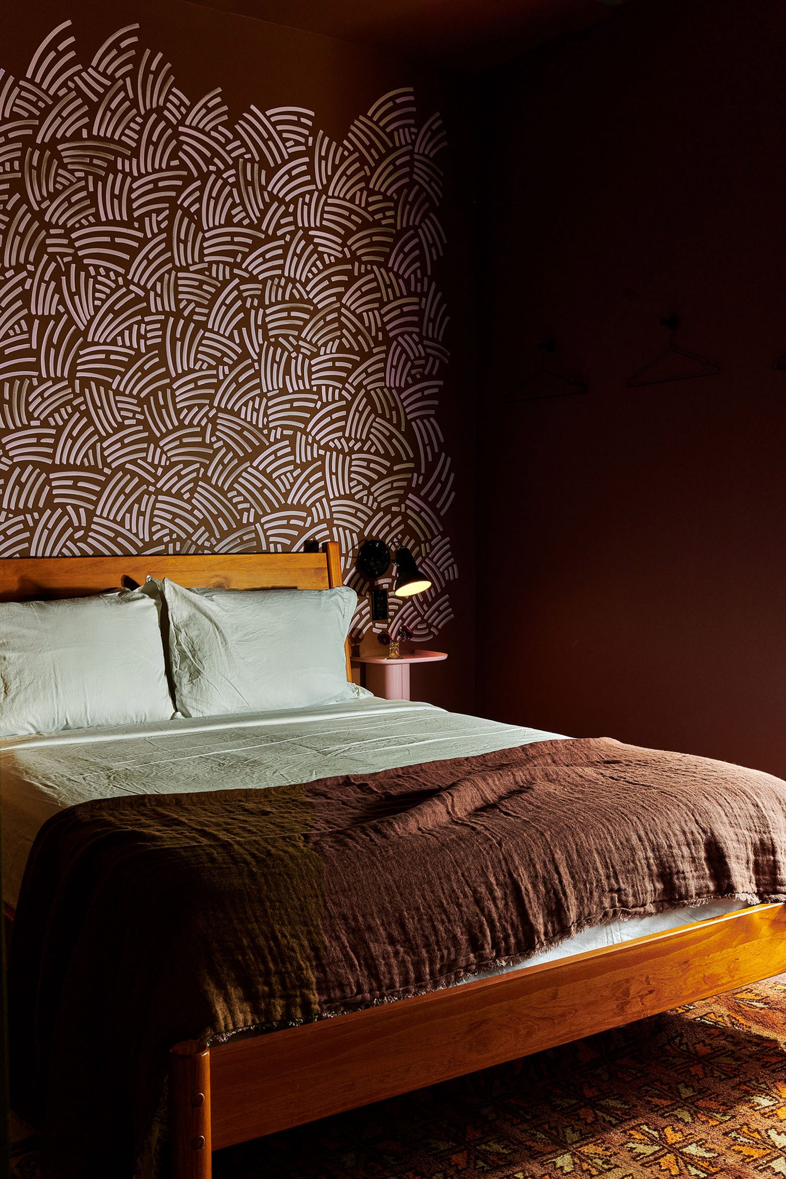 Dark red bedroom with a hand-drawn mural