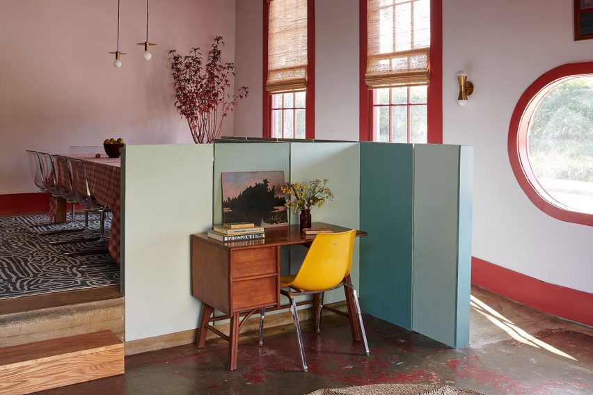 Green partitions and an antique desk in front of a raised dining room