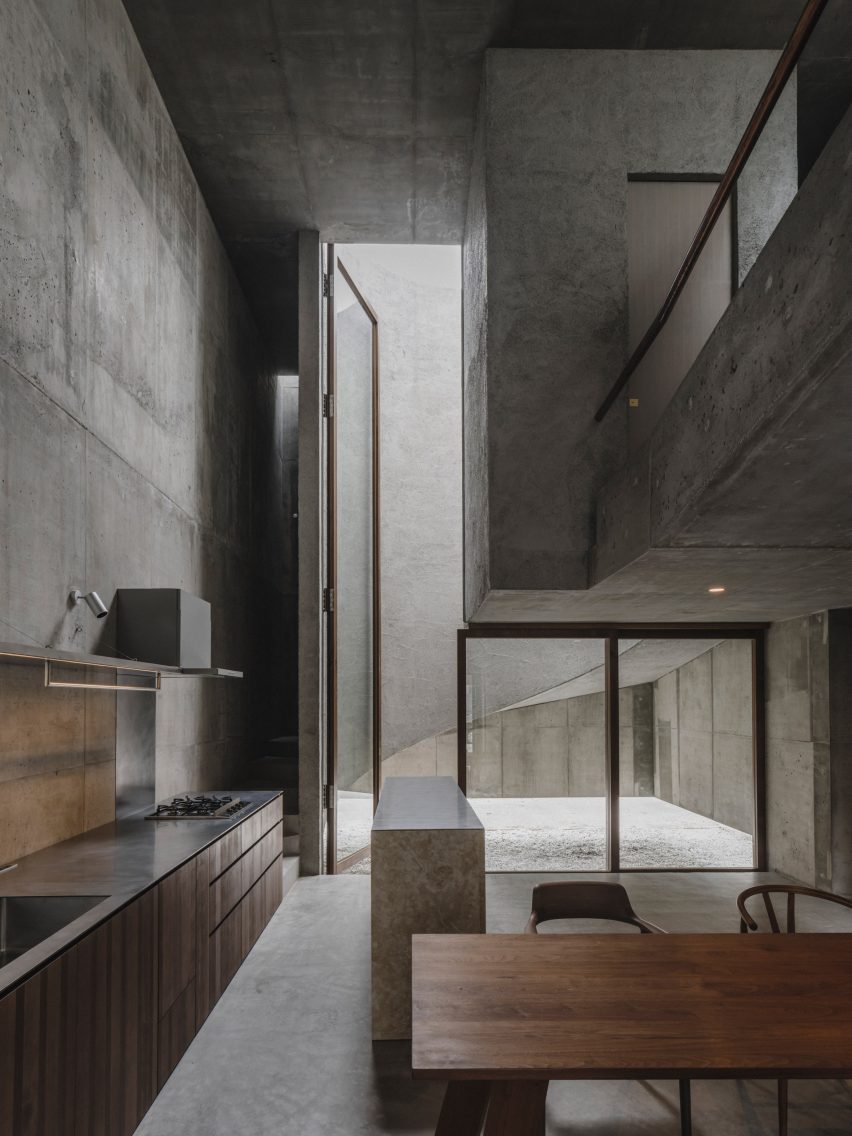 Kitchen space within concrete home by Studio Cochi Architects