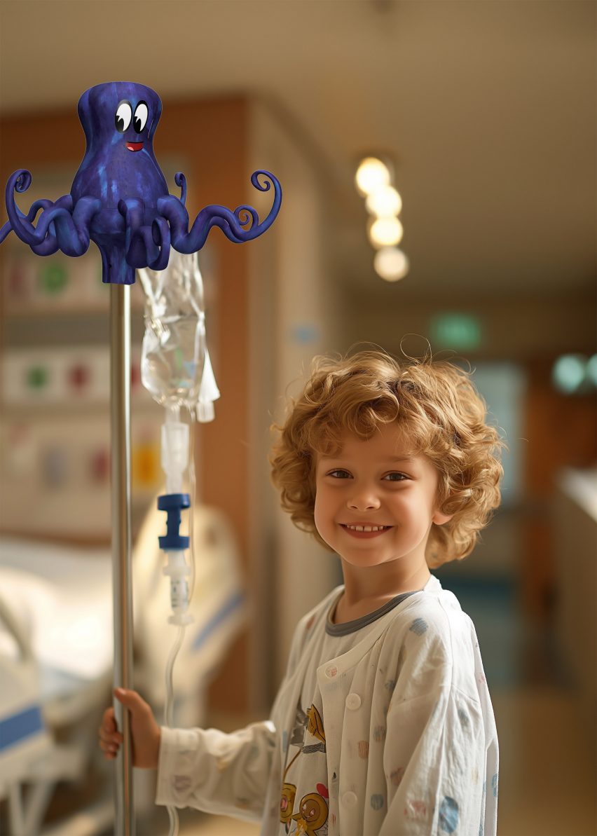 A photograph of a child in a hospital holding an intravenous pole with a blue octopus at the top of it. 