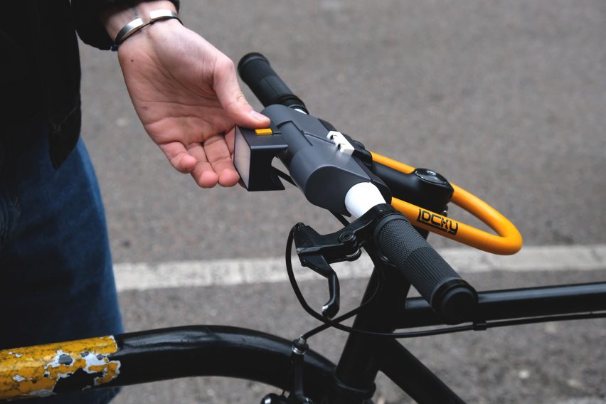 A photograph of a person handling a bike lock on a bike.