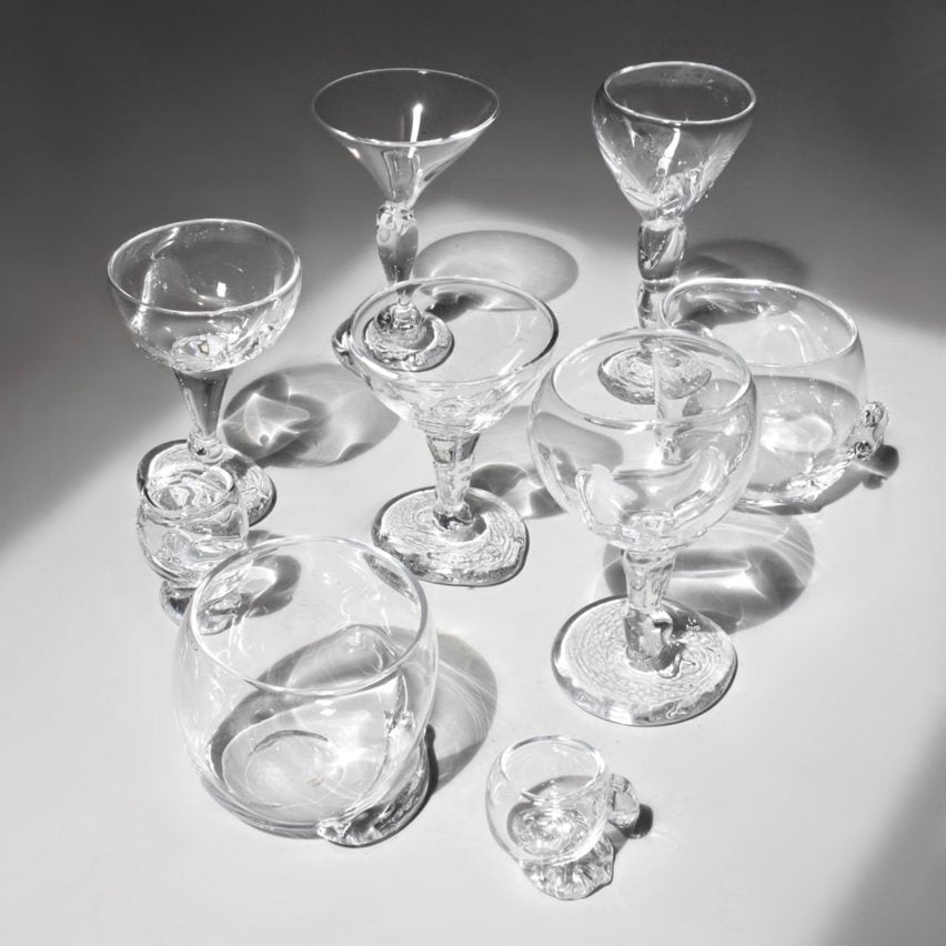 A photograph of a collection of transparent glasses against a grey backdrop.
