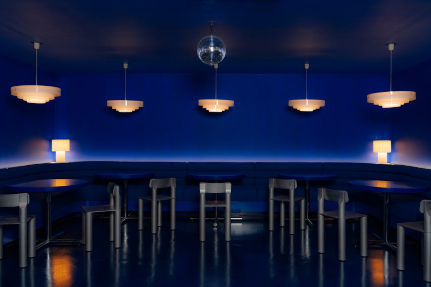 Cobalt blue lounge with tables and chairs around the perimeter