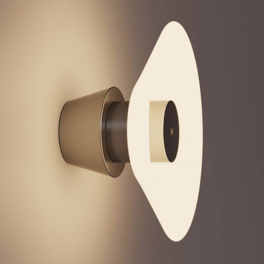 A photograph of a rounded illuminated light attached to a wall, in warm tones of beige and brown.