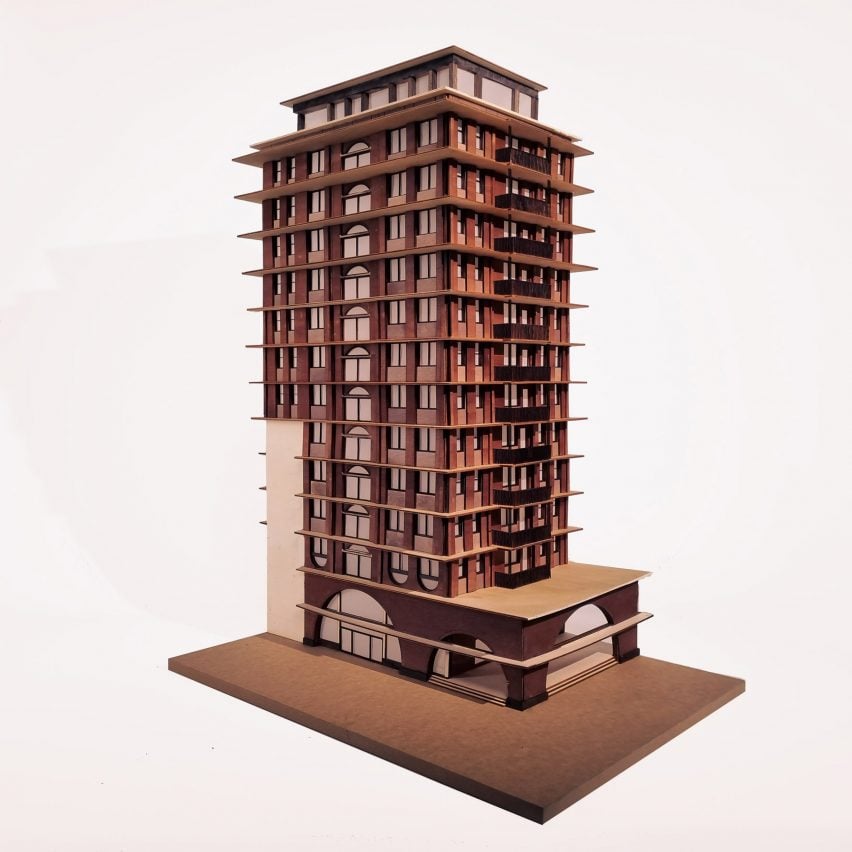 A photograph of an architectural model in tones of brown, against a white backdrop.