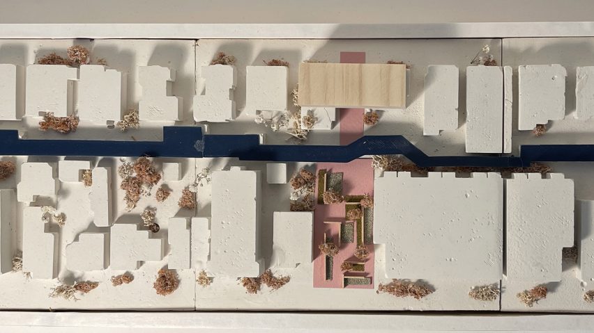 A photograph from above of an architectural model in colours of white, blue and pink.