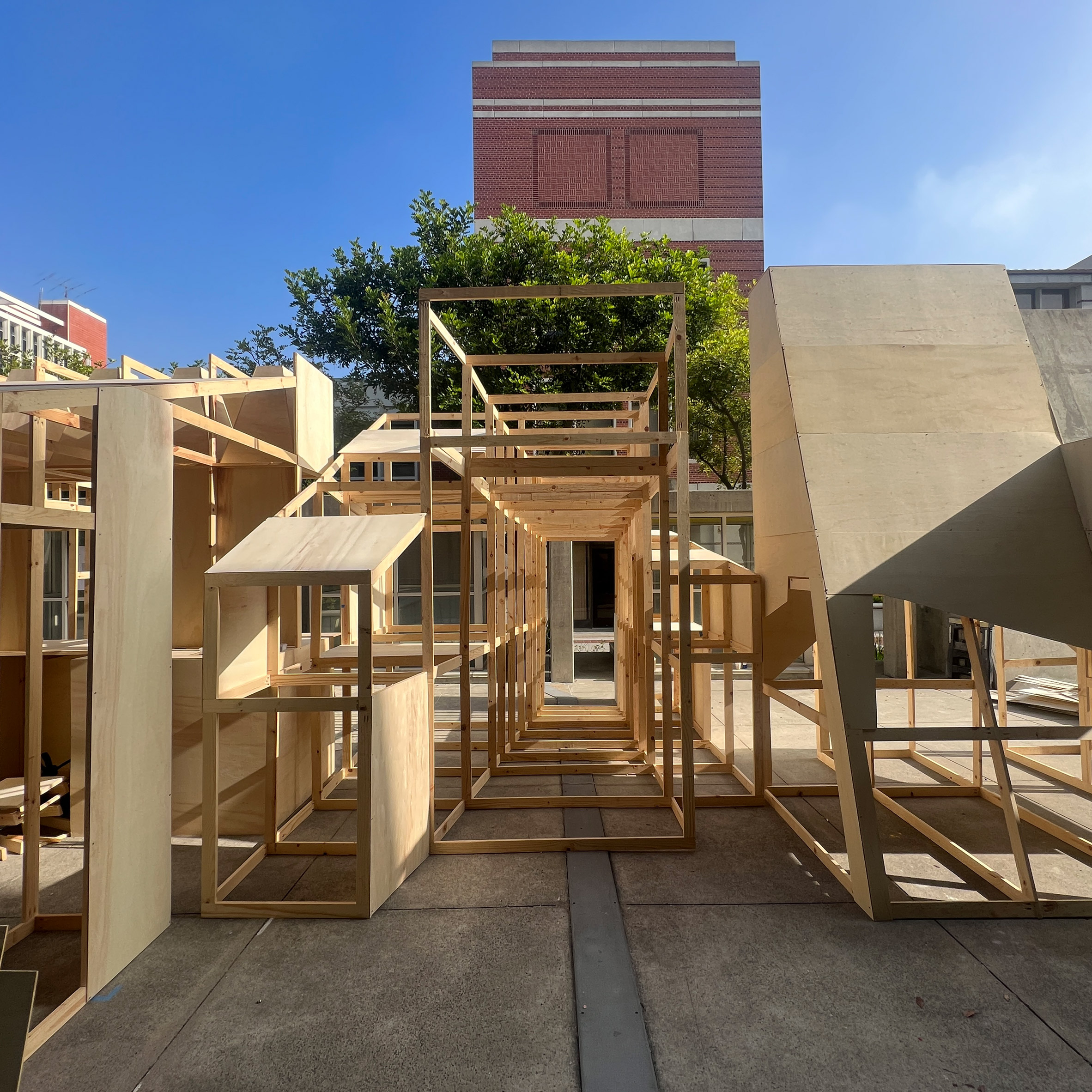 A photograph of a large wooden structure, outside against a blue sky.