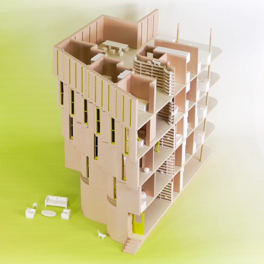 A photograph of an architectural model in tones of beige, bright green and white, against a green and white background.