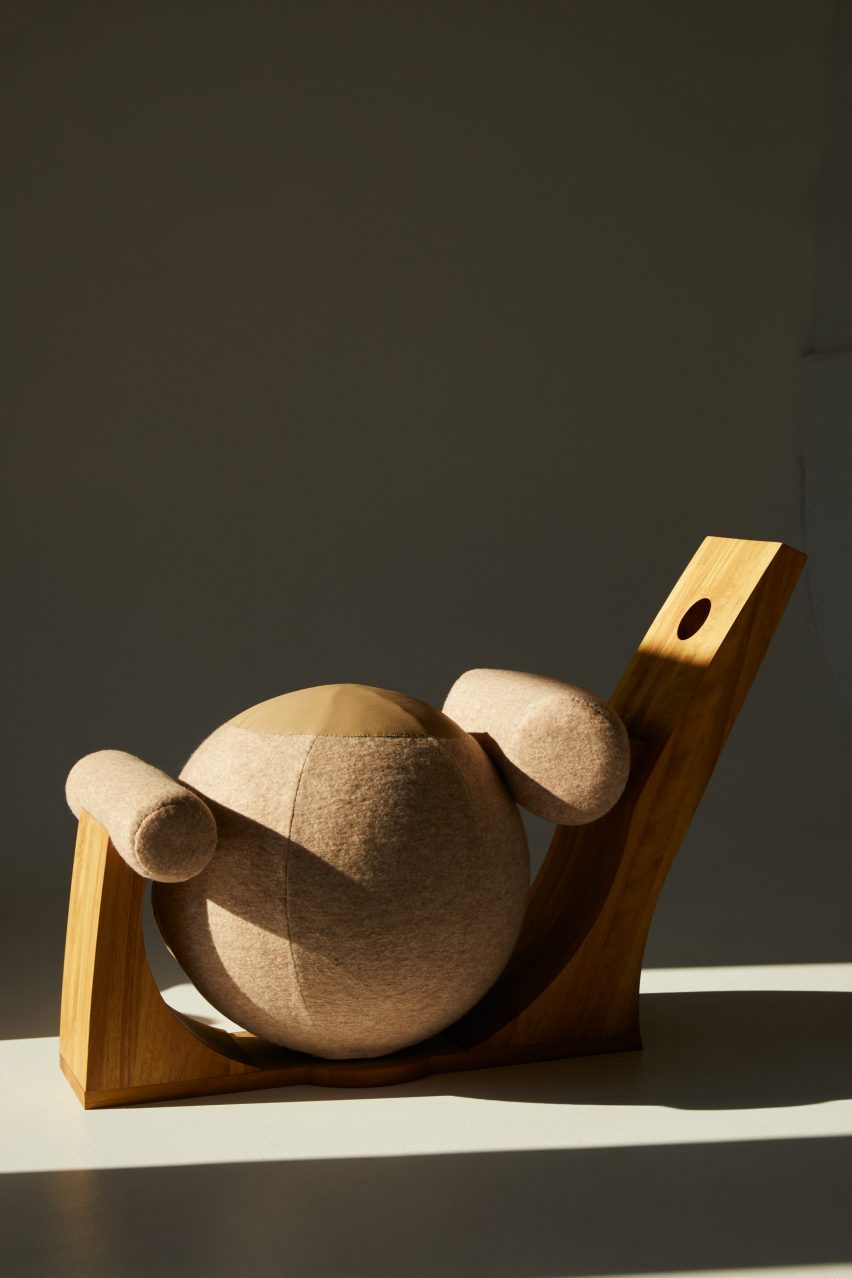 A photograph of an abstract wooden chair in circular structures, against a dark grey background.