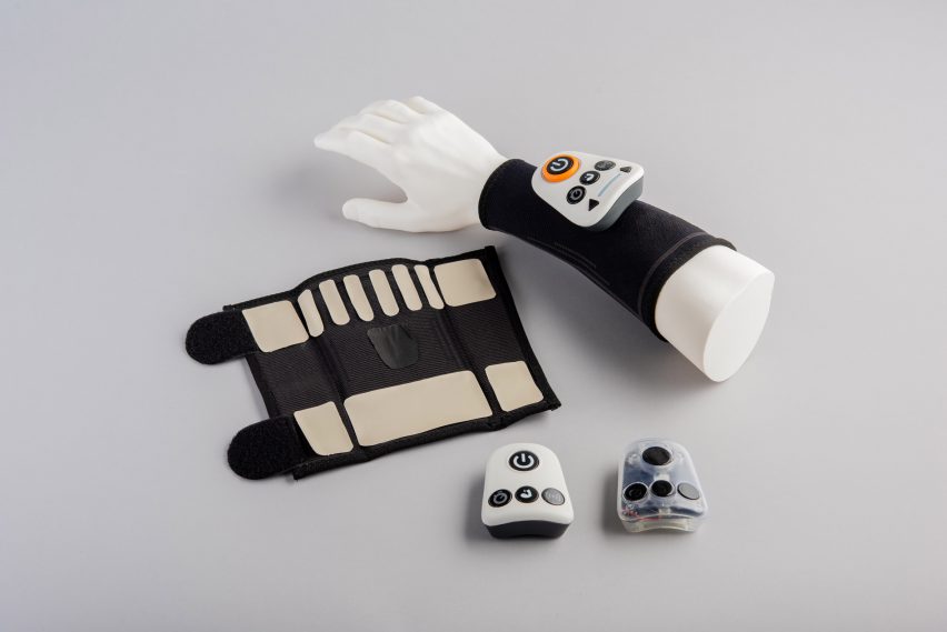 A photograph of a hand mannequin with a black band and gadget on it; with the same objects placed next to it against a grey backdrop.