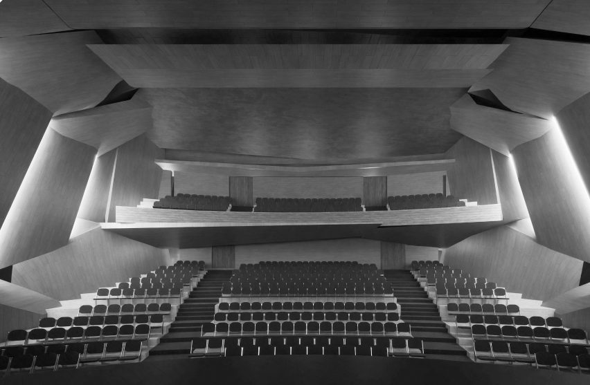 A visualisation of the interior of a large hall with seats in tones of grey, black and white.