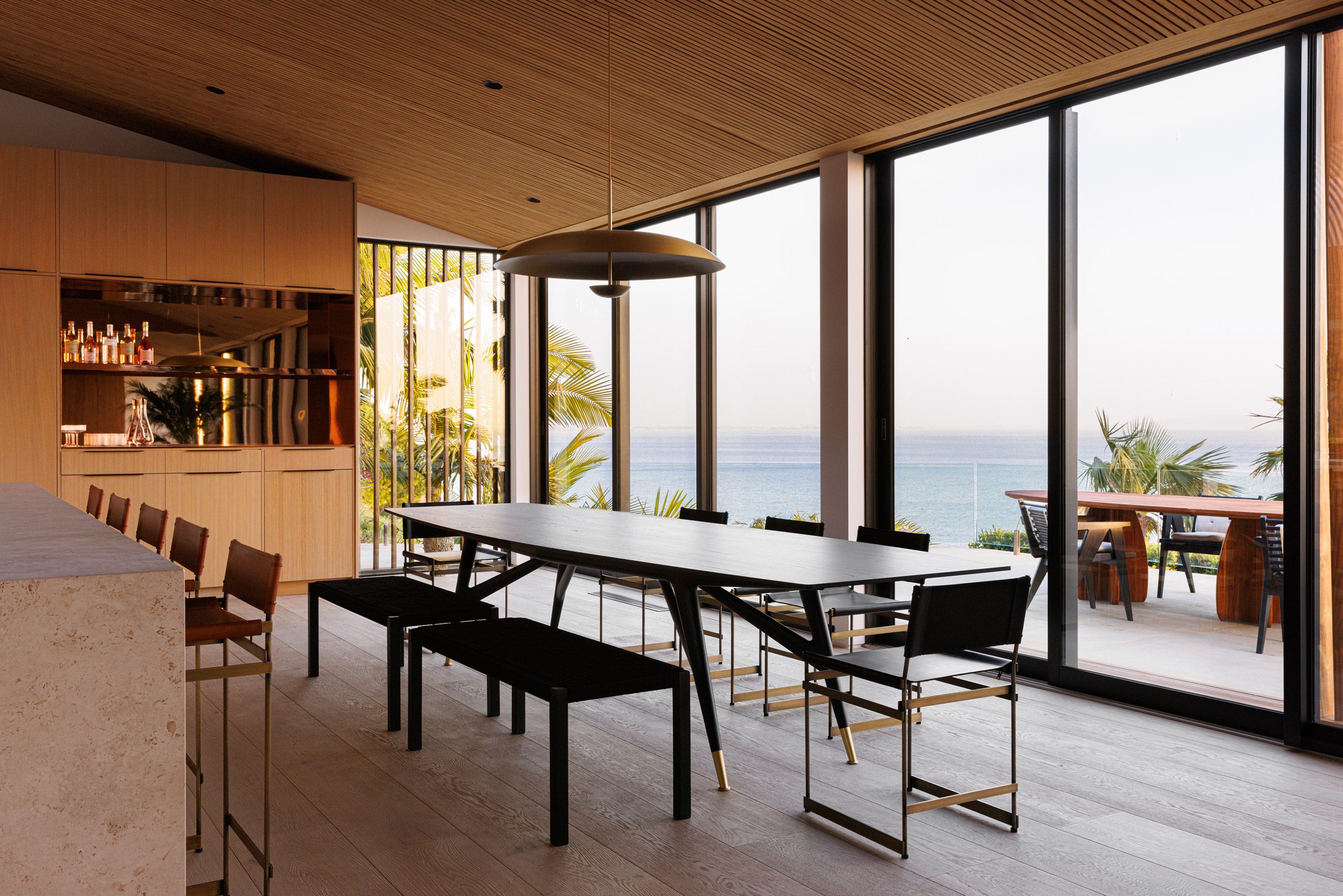 Dining room with a black Gio Ponti table overlooking the ocean