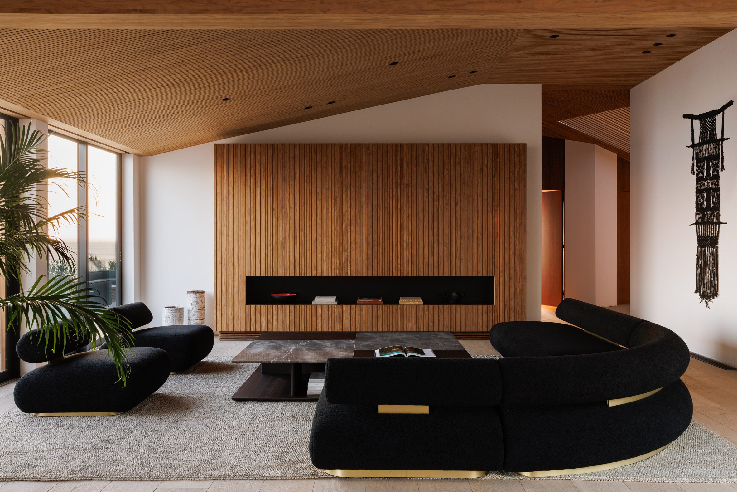 Lounge area featuring black seating and a slatted media unit