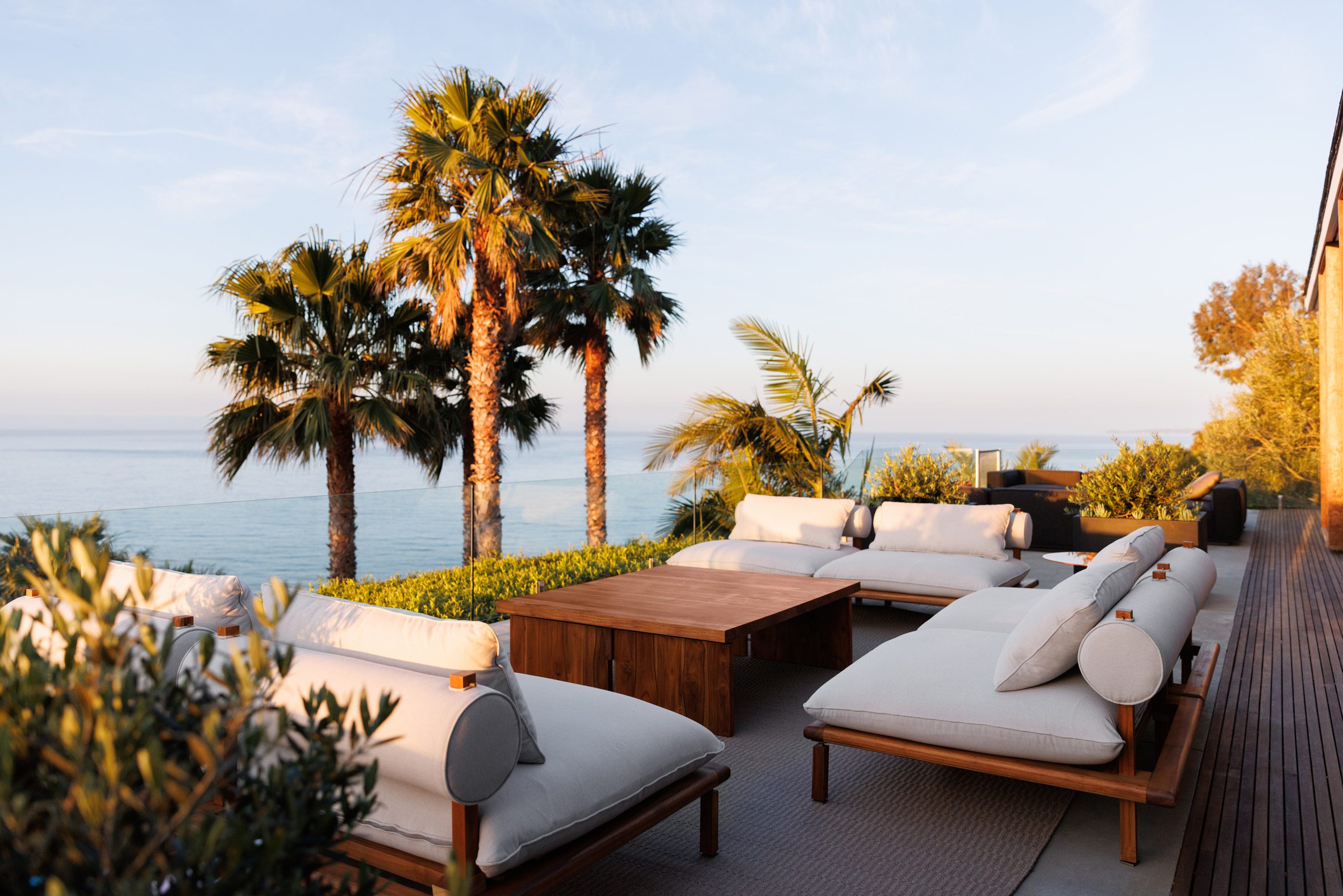 Terrace with soft seating and palm trees in the background