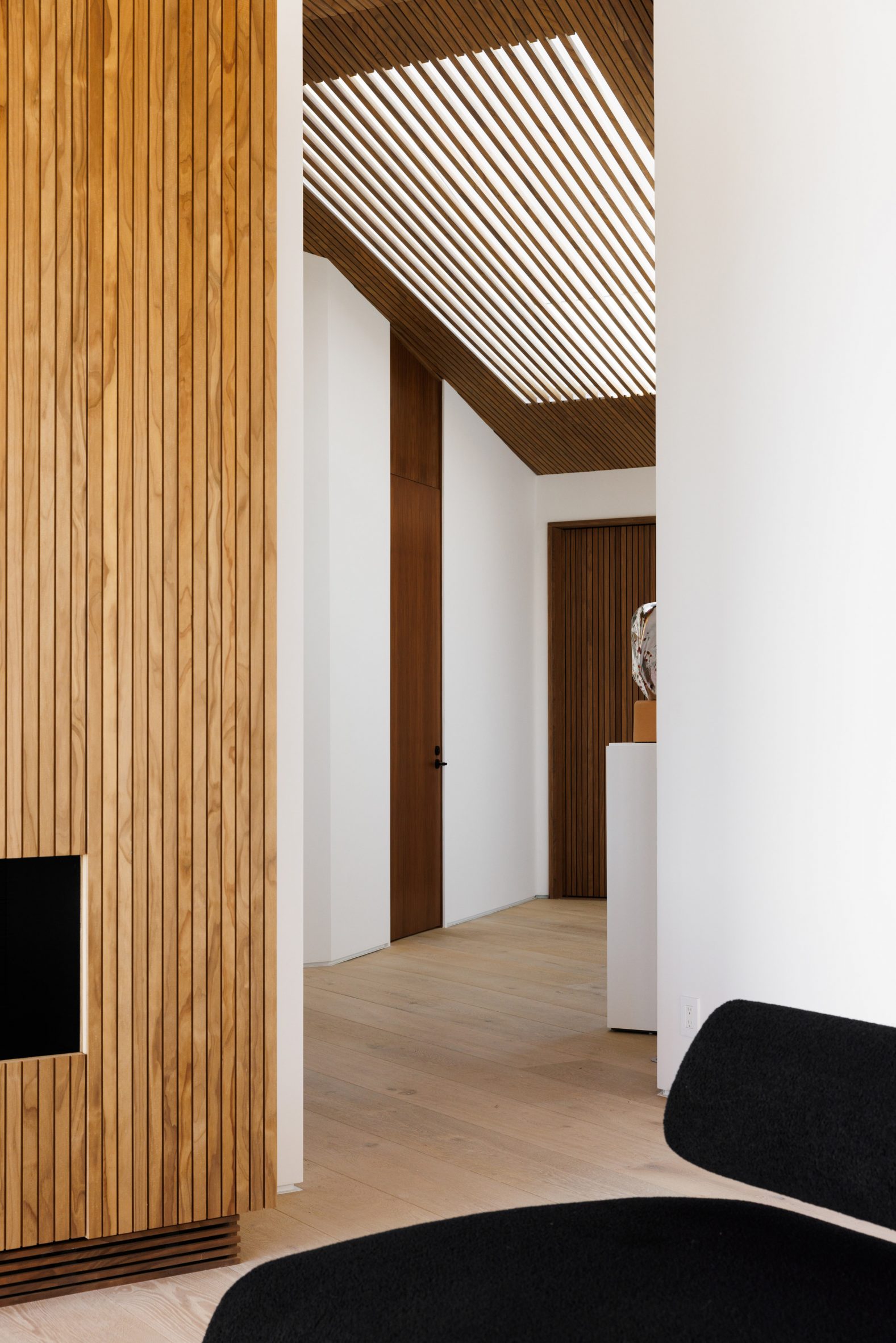 A skylight over an entryway that's partially shaded by ceiling slats