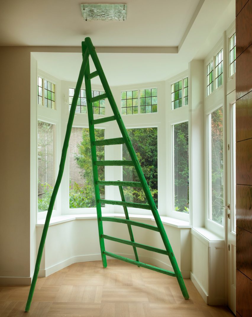 Green ladder in windowed corner