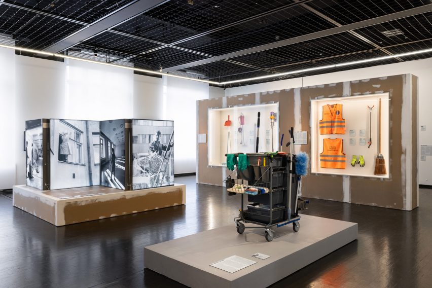 Photo of a cleaning cart on a grey plinth in a museum exhibition