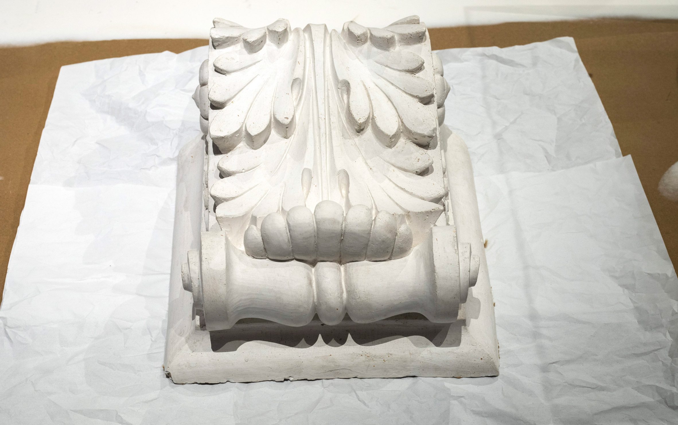 Photo of a plaster copy of a decorative volute from the main door from the Museum of Finnish Architecture building, resting on a surface