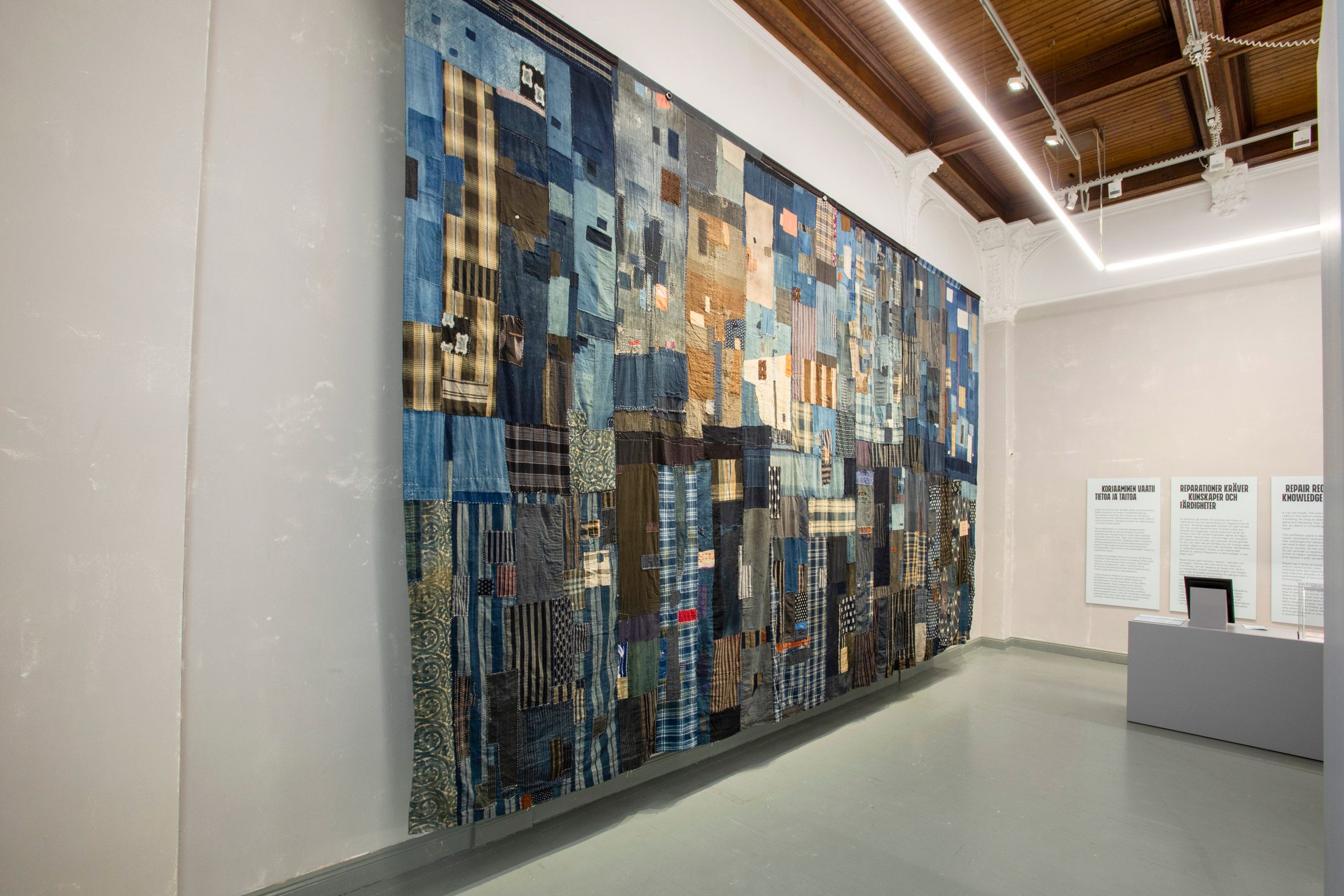 Photo of Takao Momiyama's textile work Inheritance, hanging on the wall of a museum