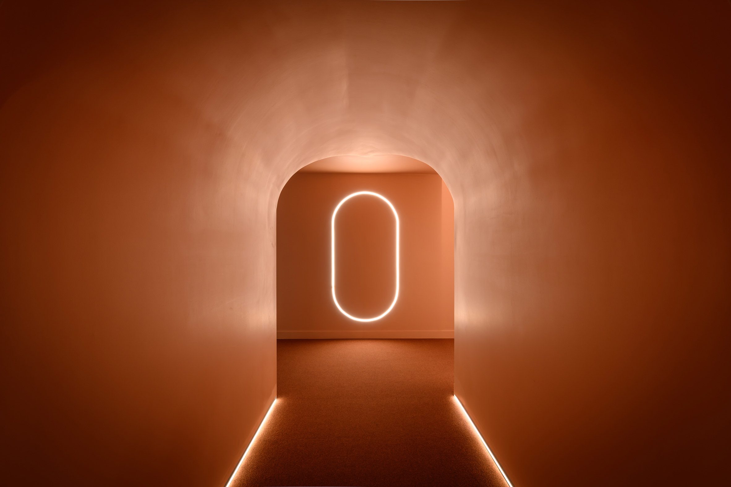 A tunnel leading to a pill-shaped LED light at the end