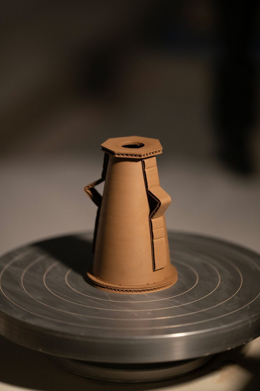 A photograph of a brown ceramic on a potters' wheel.