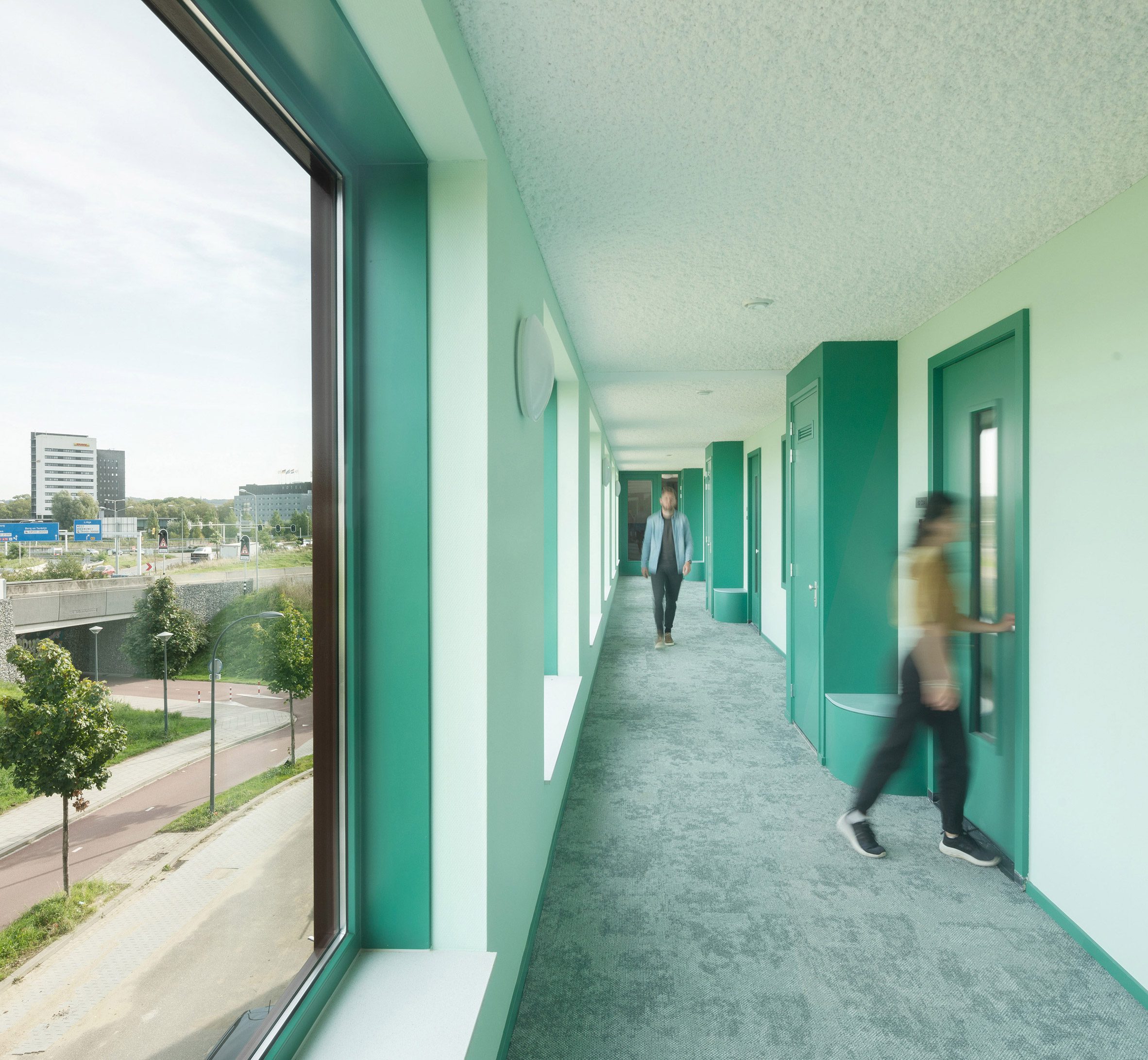 Corridor interior at brick apartment block by Martens Willems & Humblé Architecten