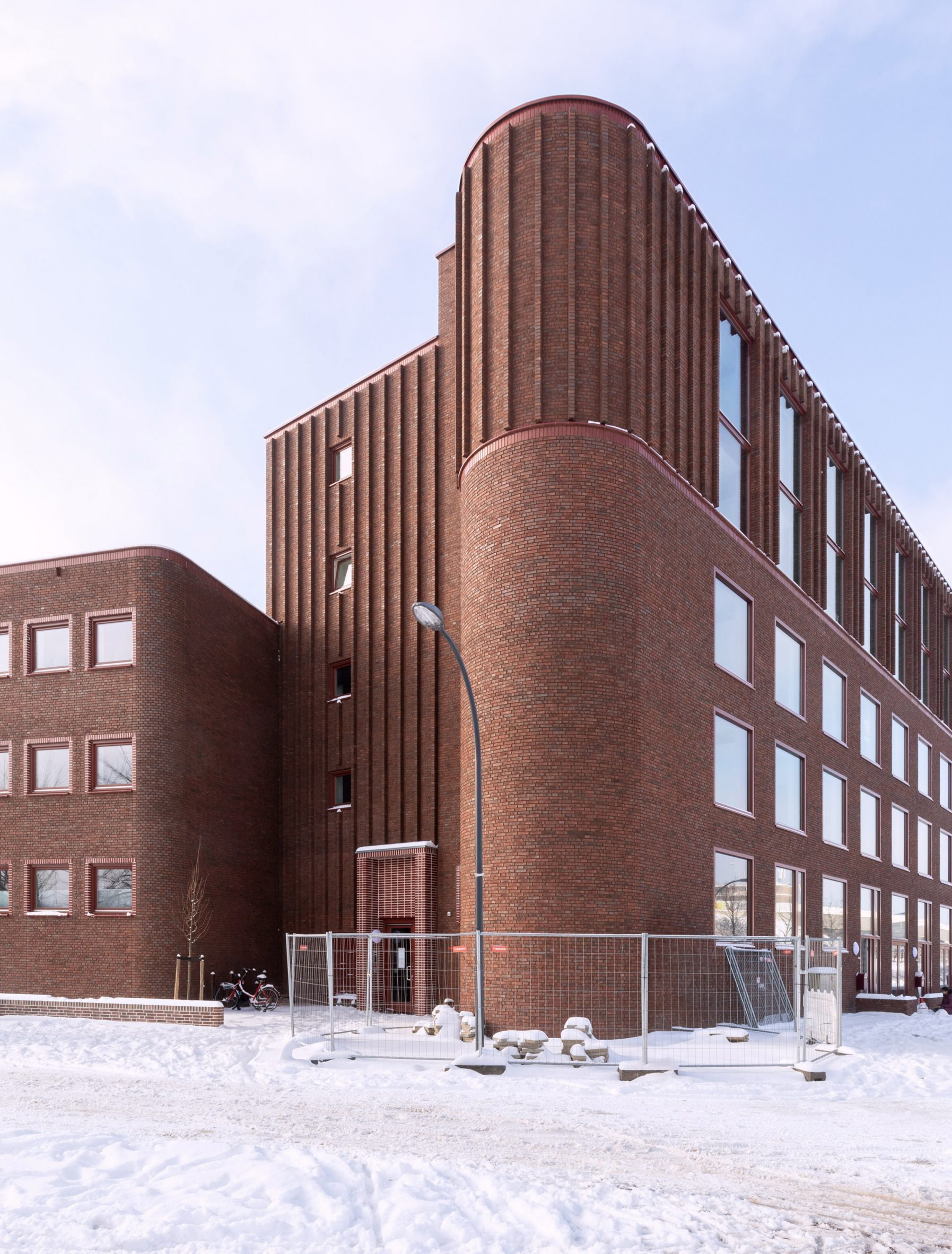 Exterior view of brick apartment block by Martens Willems & Humblé Architecten