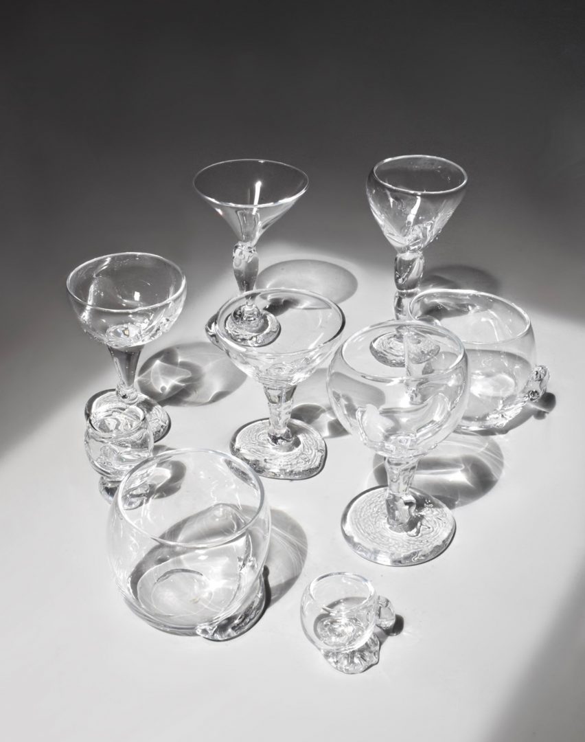 A photograph of a collection of transparent glasses against a grey backdrop.